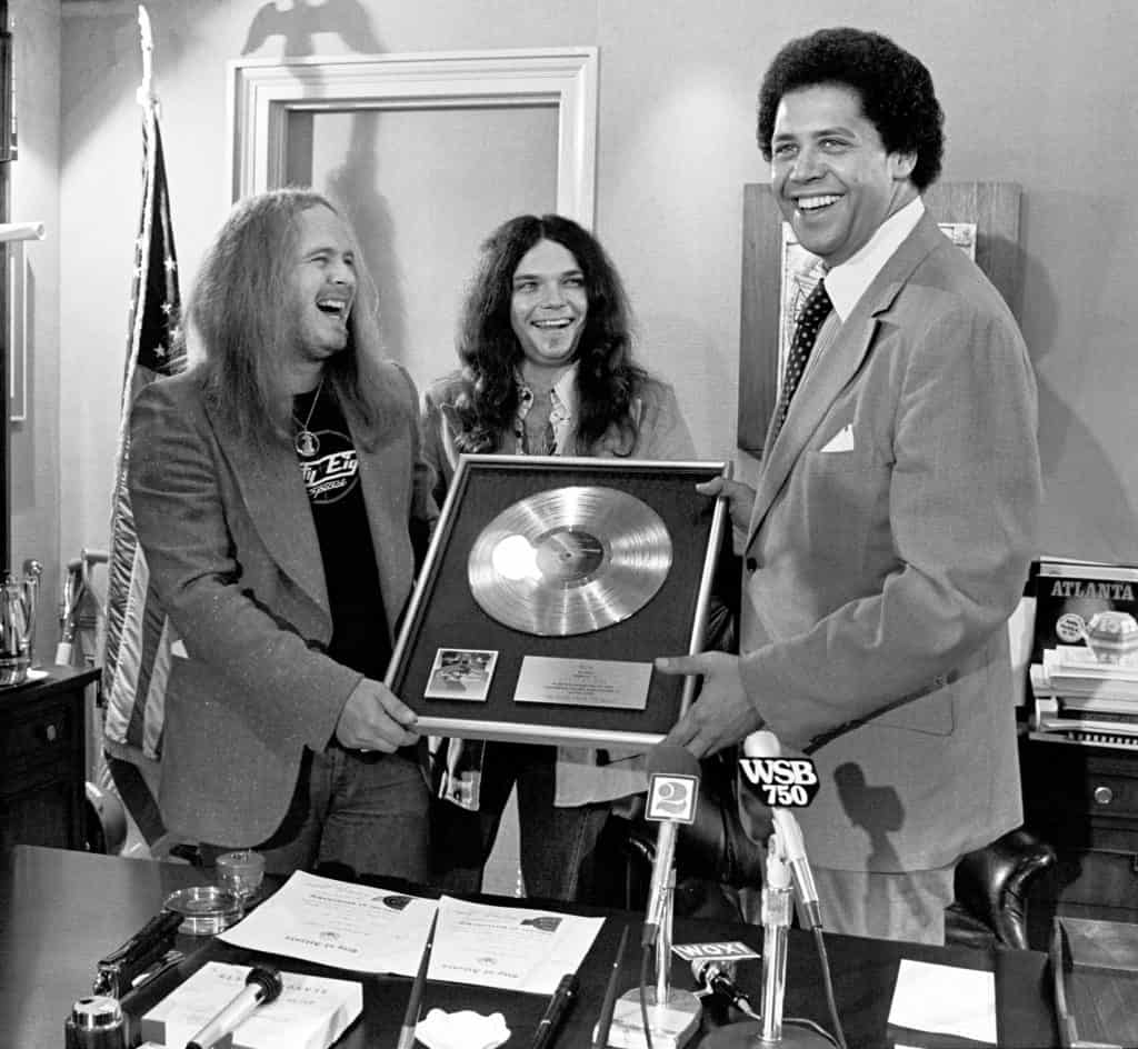 Taken in April 1977, this picture shows Gary Rossington and Ronnie Van Zant presenting Atlanta Mayor Maynard Jackson with a gold record of their live album One More from the Road.