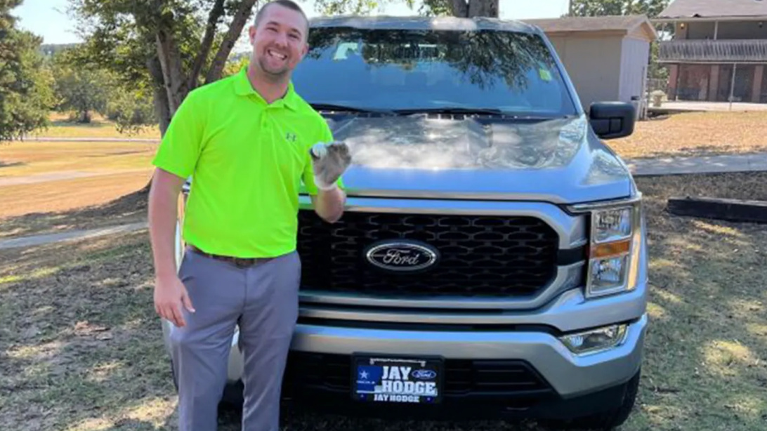 Austin Clagett poses with his hole-in-one ball and the truck he thought he won.