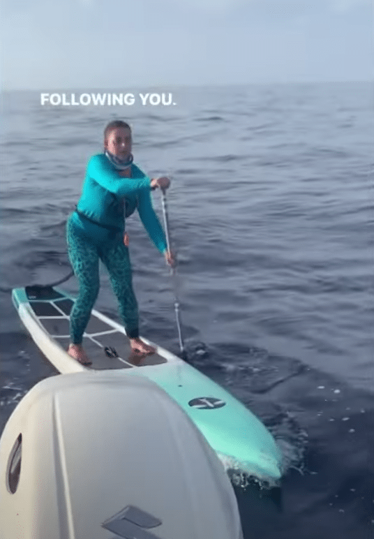 She cautiously paddles back to the boat after realizing it was a shark!