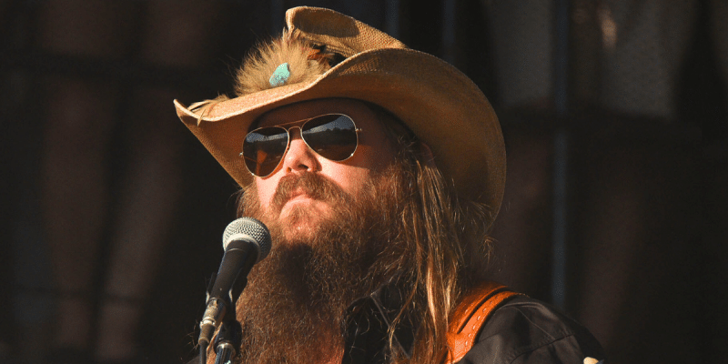 Chris Stapleton is photographed here wearing his sunglasses and guitar during a concert