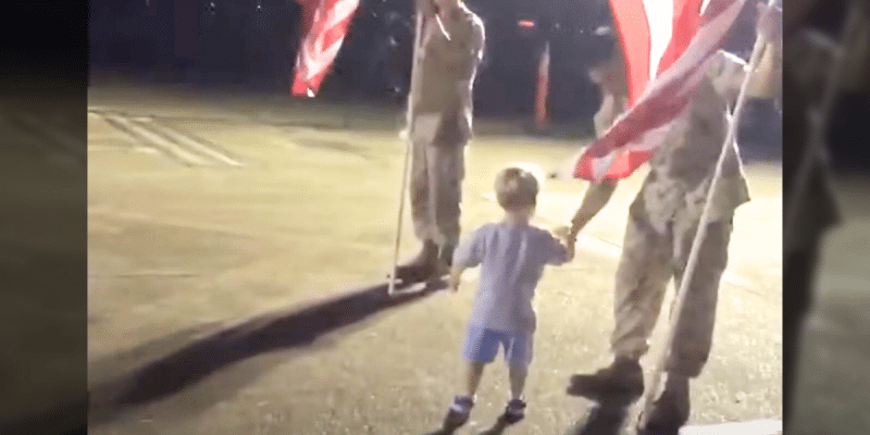 Two-year-old child shaking a veteran's hand