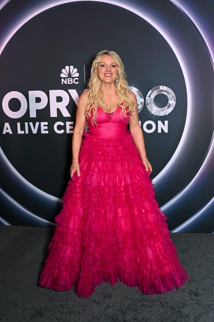 Rhonda Vincent in a hot pink dress on the Opry 100 red carpet.