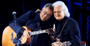 Ricky Skaggs embraces Vince Gill after singing with him on the "opry 100" tv special.