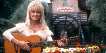 Dolly Parton poses for a portrait with her guitar at Dollywood circa 1993 in Pigeon Forge